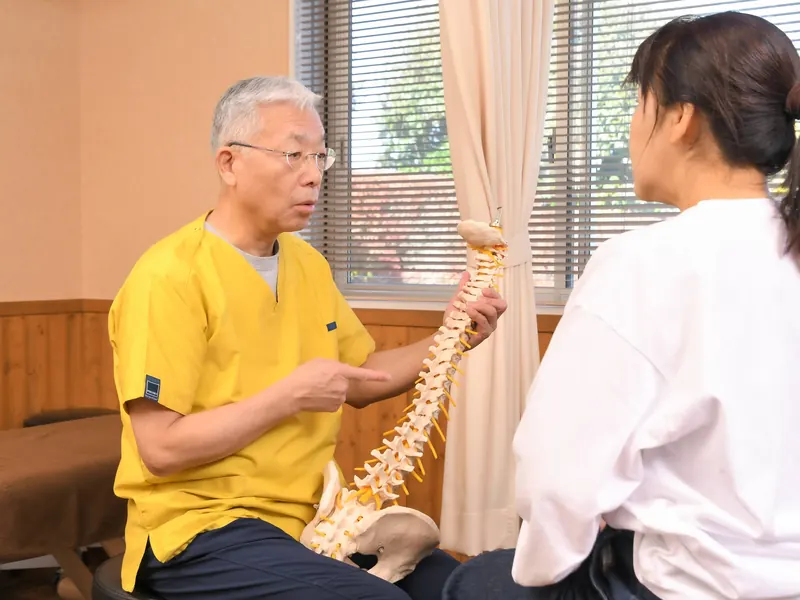 院長が背骨の模型を使って説明している様子