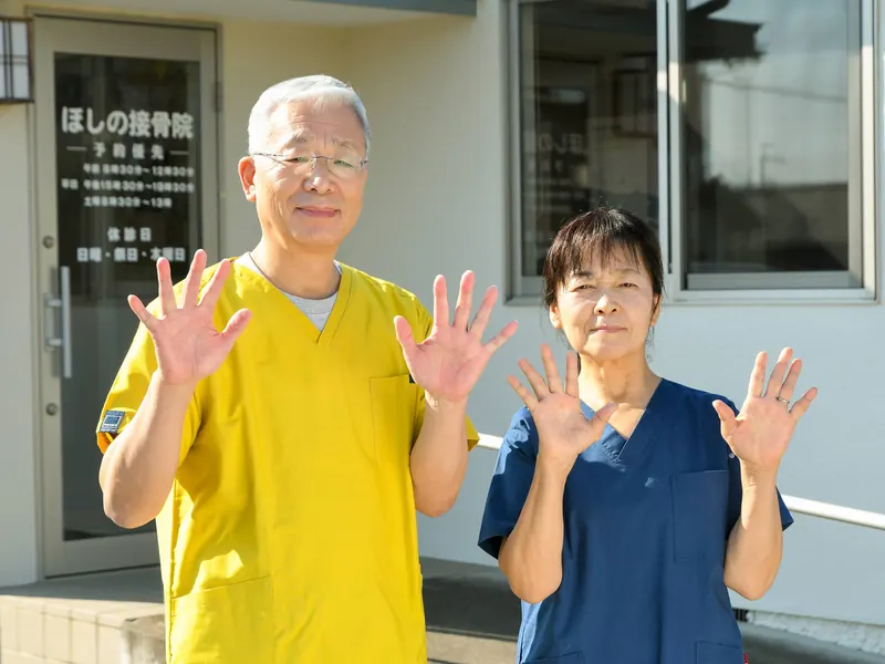 院の前で手を振る院長と受付スタッフ