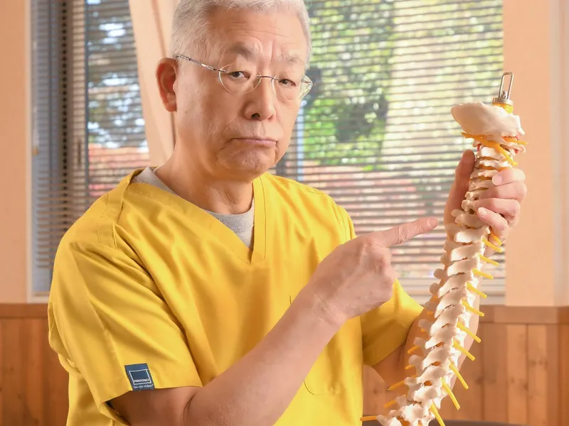 院長が背骨の模型を手に説明している様子