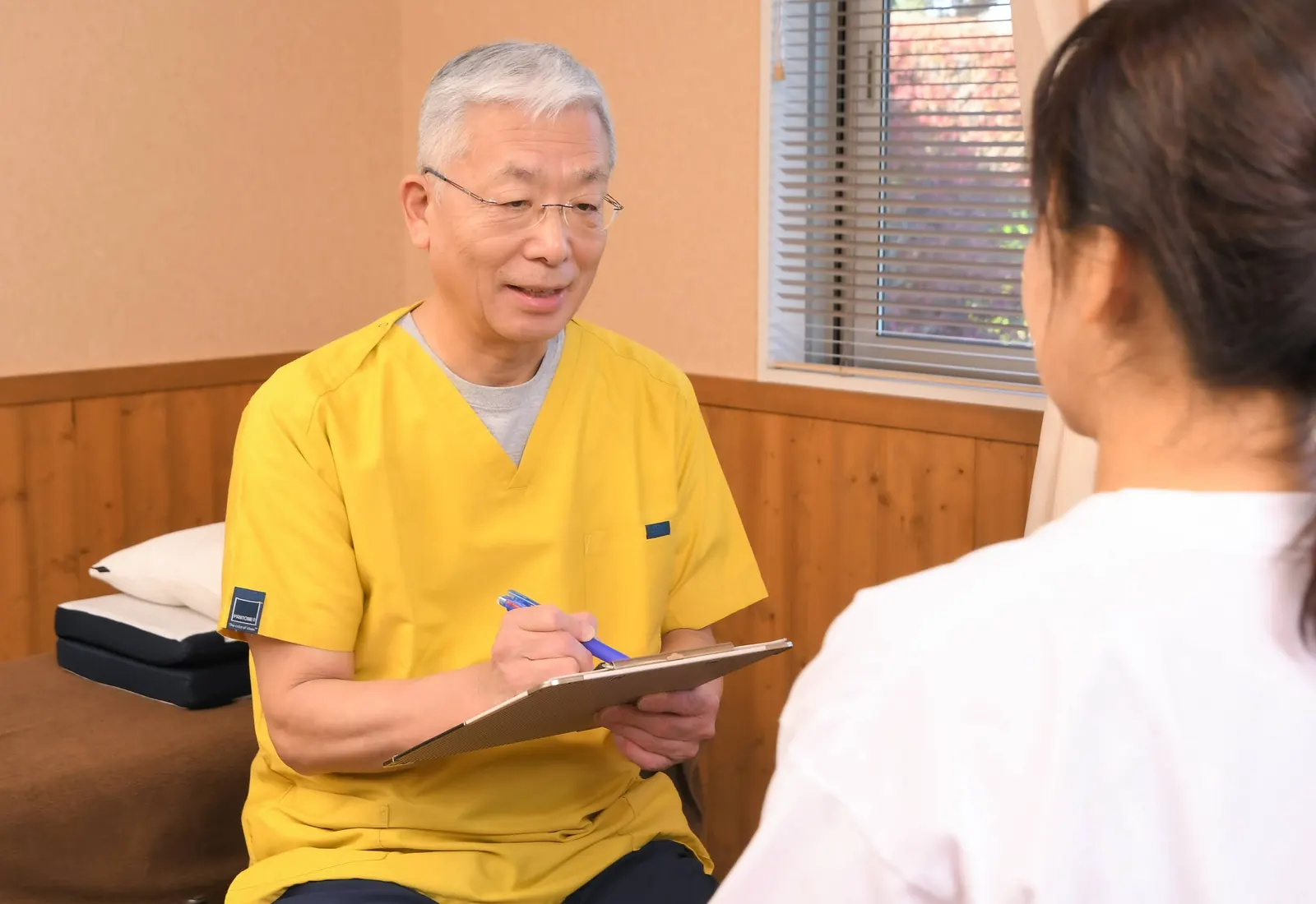 院長の星野が問診票を手に、患者様のお話を伺っている様子