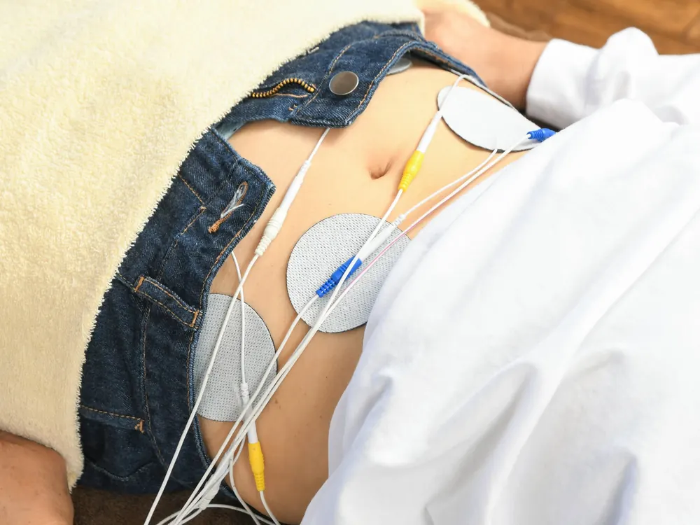電気施術のパッドを腰に付けている様子