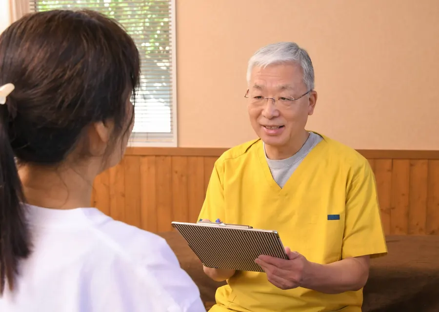 院長が問診票を手に、患者様と向き合って話を聞いている様子