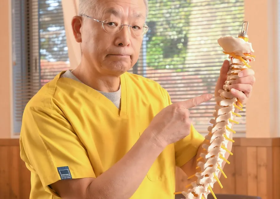 院長が背骨の模型を使って説明している様子