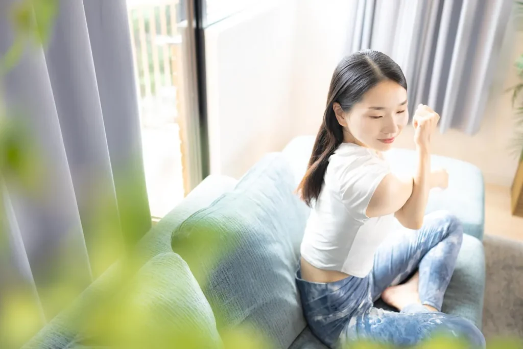 ソファでストレッチをする女性