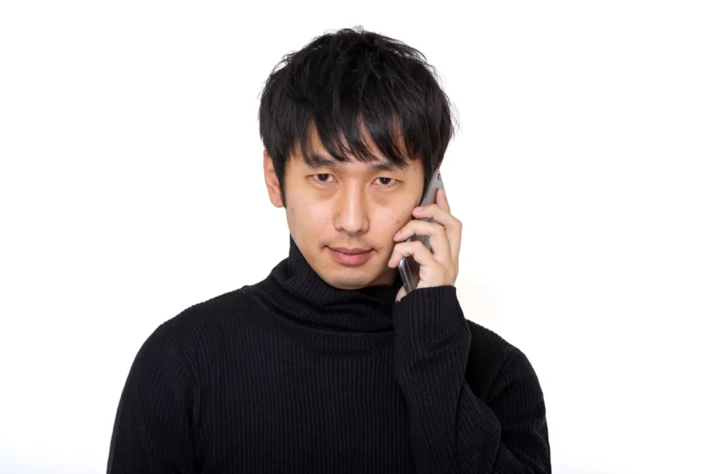 通話する黒タートルネックの男性