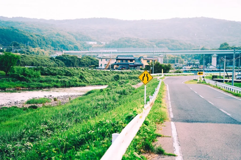 河川敷沿いの道路と黄色い標識