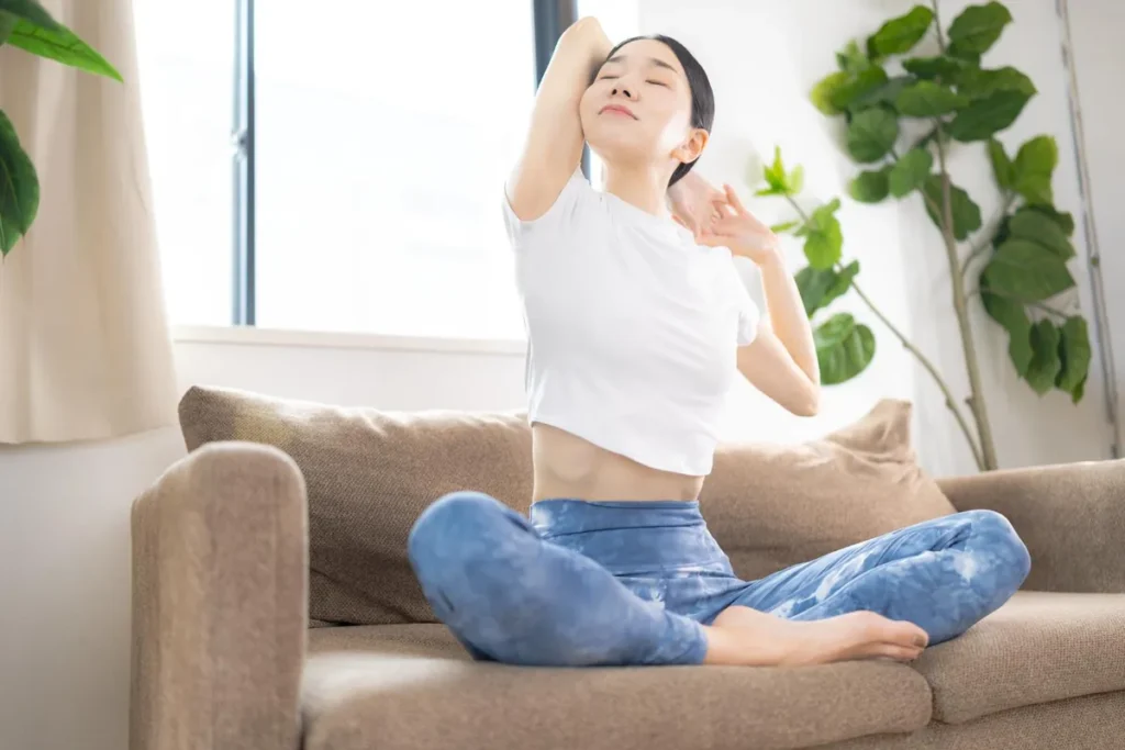 ソファでくつろぎながら上半身を大きく伸ばすストレッチタイム