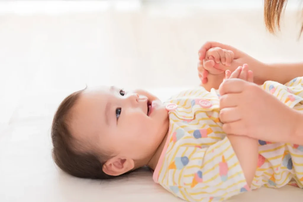 笑顔の赤ちゃんとママの手